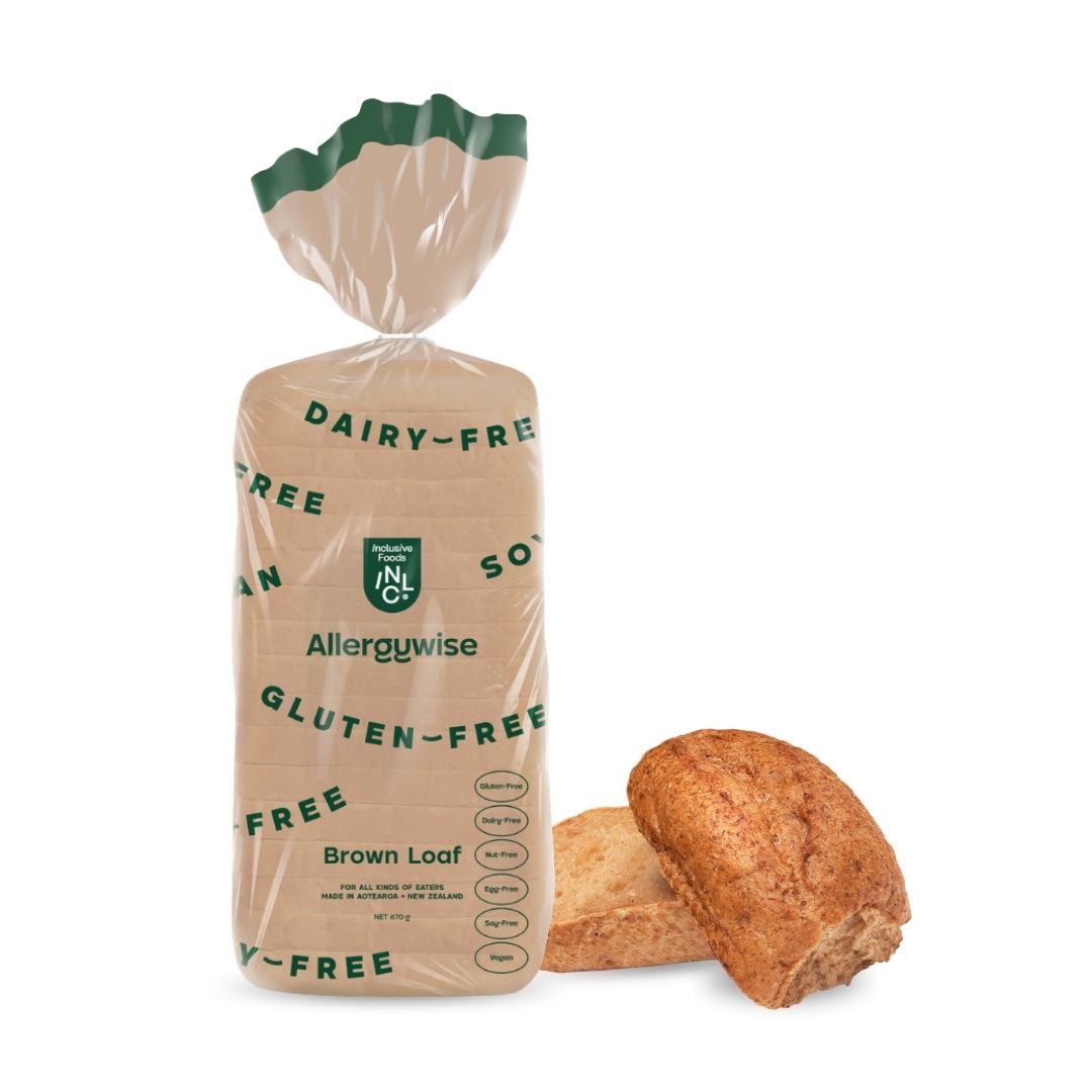 A package of Allerguywise Gluten-Free Dairy-Free Brown Loaf bread, shown in its clear plastic bag with green text and a green top seal, with two sliced loaves displayed next to it on a white background.